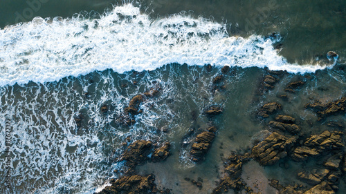 pazific ocean surf meets shore, drone shot from the beach of vietnam, wild ocean hit the rocks