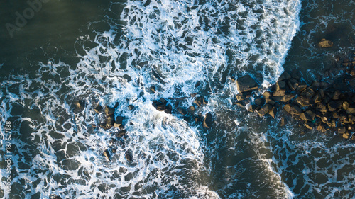 pazific ocean surf meets shore, drone shot from the beach of vietnam, wild ocean hit the rocks photo