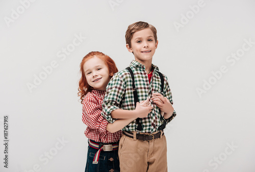 adorable little kids hugging and smiling at camera isolated on grey