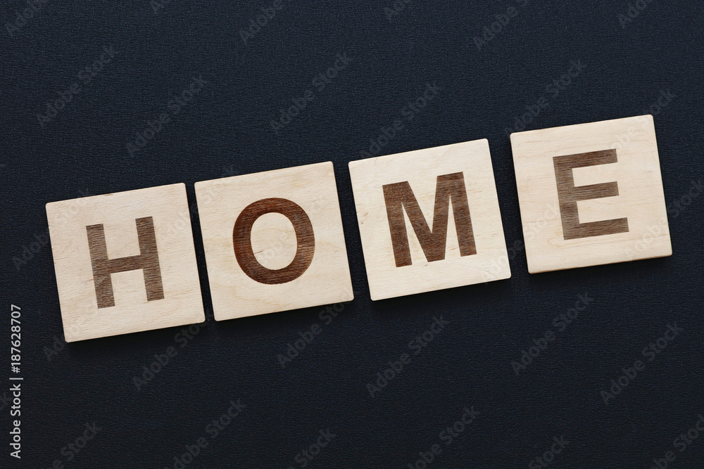 Obraz premium Word HOME on wooden signs over black