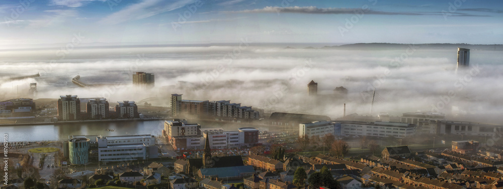 Editorial SWANSEA, UK - JANUARY 01, 2018: An unusual early morning heavy fog or sea mist engulfs the city of Swansea, South Wales, UK with only a few tall buildings showing through.