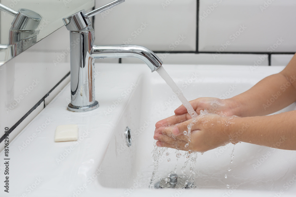 Kid washing hands in a white basin with a bar of white soap. Kid washing hands in a white basin with a bar of white soap.