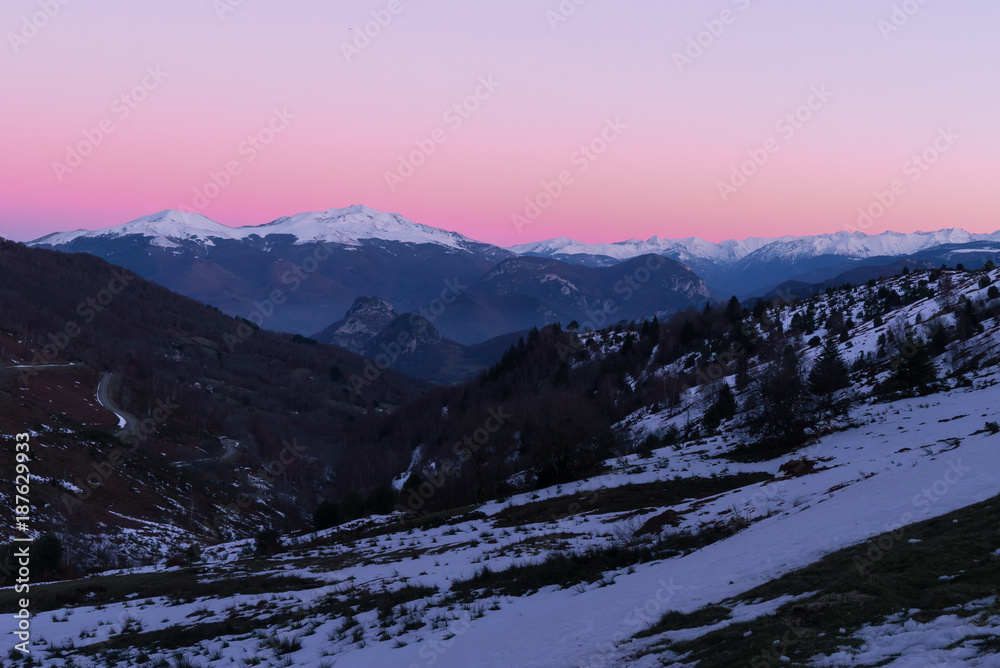 A pink sky after a sunset on mountains covered with snow in Pyrenees