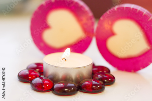 St. Valentine's Day concept with a burning white candle and lolipop candies, close up, white background