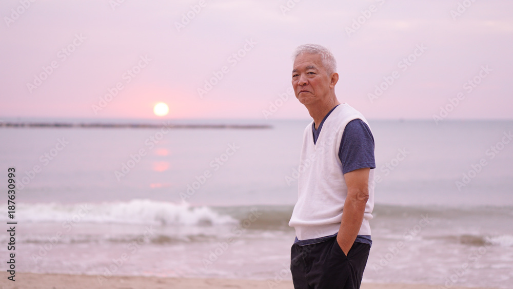 Asian senior man standing alone at sunrise morning copy space Asian senior man standing alone at sunrise morning copy space