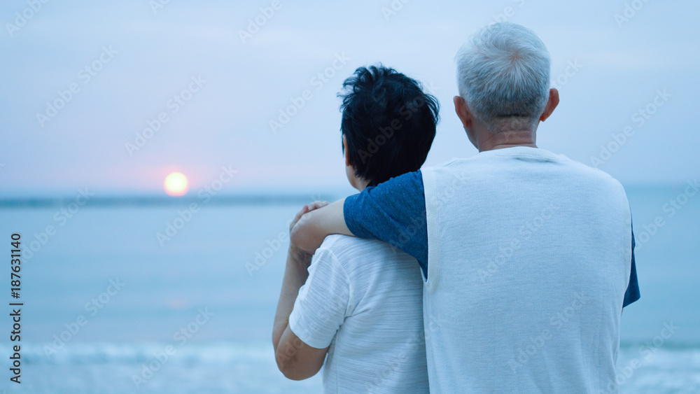 Asian senior couple dating at sunrise sea Asian senior couple dating at sunrise sea