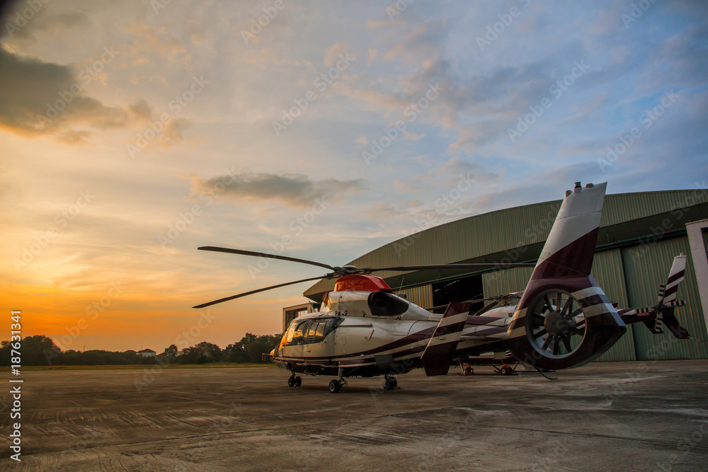 silhouette of helicopter in the parking lot or runway with sunrise background,twilight helicopter on the helipad