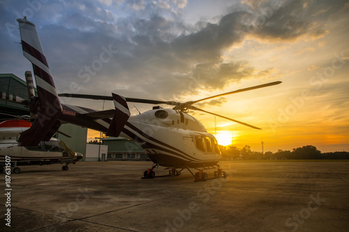 silhouette of helicopter in the parking lot or runway with sunrise background,twilight helicopter on the helipad