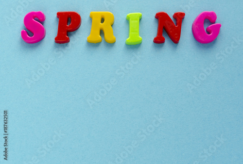 word "spring" of plastic magnetic letters on blue background