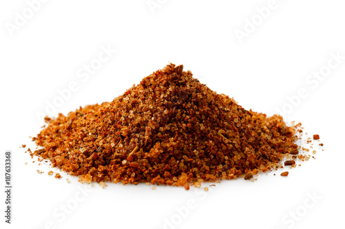 A pile of a red bbq spice mix ioslated on white.