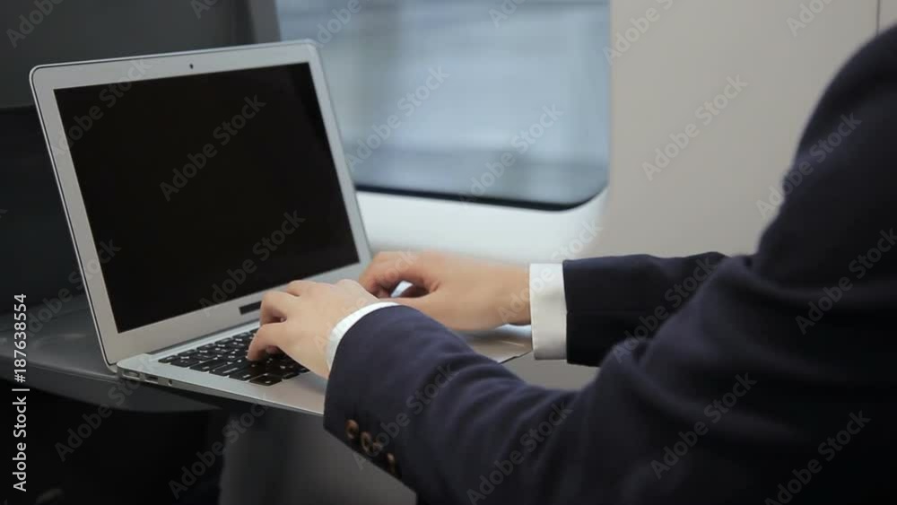 Male fingers of businessman print on laptop keyboard train. Man during travel on transport writes text and presses on touchpad on wireless computer. Male fingers of businessman print on laptop keyboard train. Man during travel on transport writes text and presses on touchpad on wireless computer.