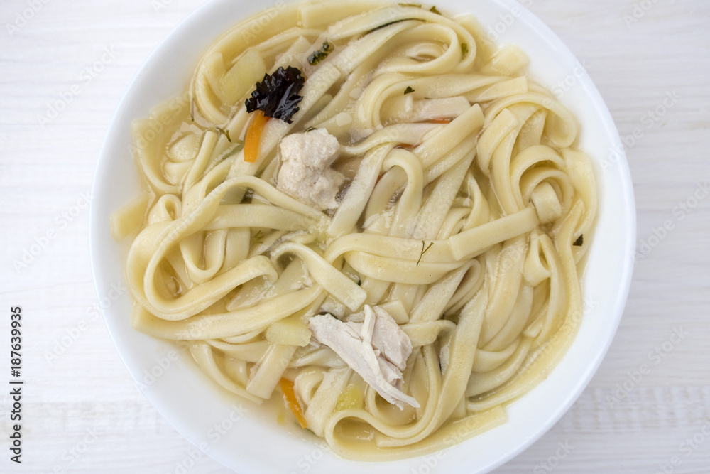 Appetizing chicken soup with noodles, with the addition of potatoes, carrot greens and bay leaf. Appetizing chicken soup with noodles, with the addition of potatoes, carrot greens and bay leaf.