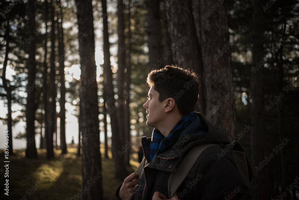 young man looking somewhere in forest young man looking somewhere in forest