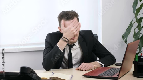 Young businessman in suit sitting in office and doing facepalm 60 fps