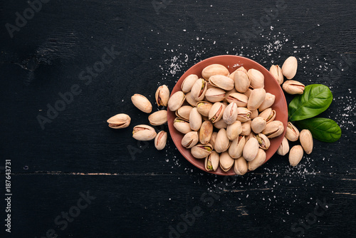 Pistachio nuts on a dark wooden background. Healthy snacks. Top view. Free space for text.