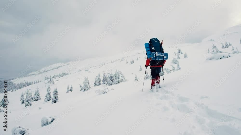 Traveler hiking on snow hills over the clouds. Winter sport activity. Traveler hiking on snow hills over the clouds. Winter sport activity.
