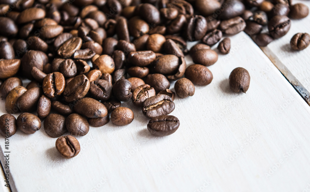 Close up of many coffee beans with annis on white wooden table. Close up of many coffee beans with annis on white wooden table.