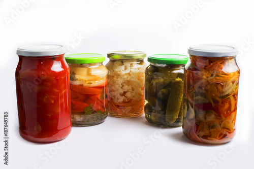 Glass jars with different colorful canned salads isolated on white background