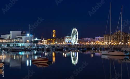 Bari seafront night Citylights cityscape. Ferris Wheel on coastline at twilight
