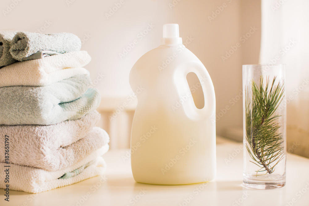An abstergent, folded towels and vase on a table in the room An abstergent, folded towels and vase on a table in the room