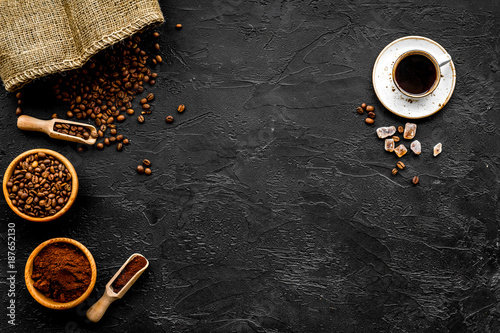 Coffee concept. Roasted beans, ground coffee, cup of espresso and sugar on black background top view copy space