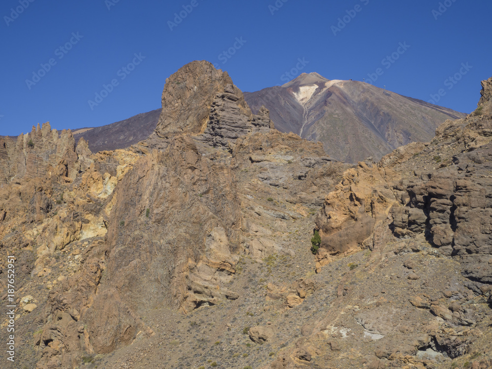 view on colorful volcano pico del teide highest spanish mountain from famous pitoresque rock formation Roques de Garcia with clear blue sky