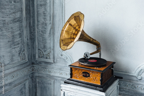 Music device. Old gramophone with plate or vinyl disk on wooden box. Antique brass record player. Gramophone with horn speaker. Retro entertainment concept. photo