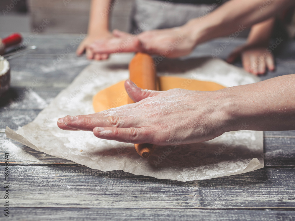 Women's hands roll out a dough for house baking. Home-made pastries. Close up