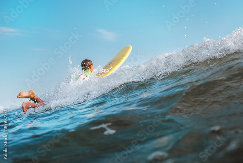 Photography Boy floats on surf board over the wave crest