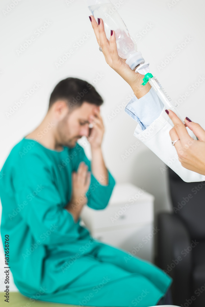 Female doctor prepares an injection while the patient is in bed