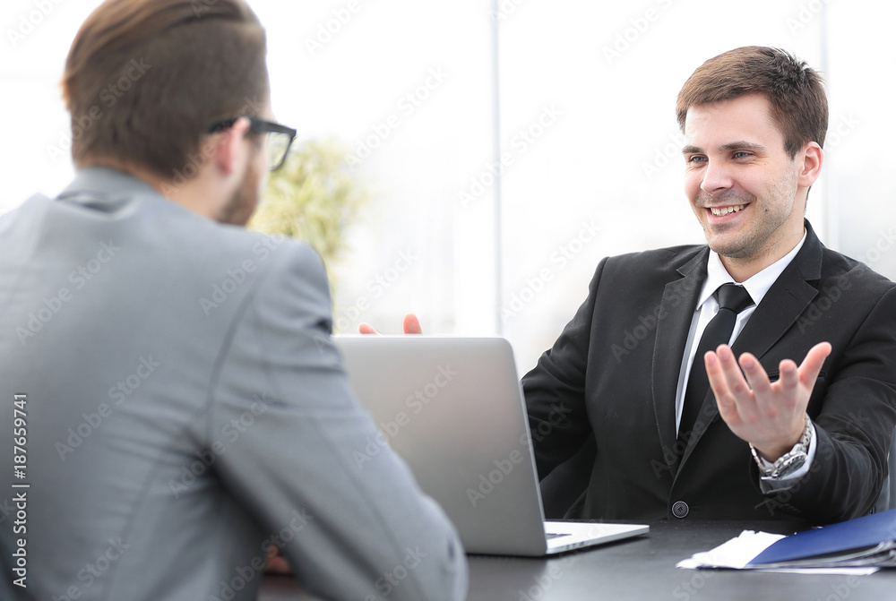 employees of the company talking at his workplace employees of the company talking at his workplace
