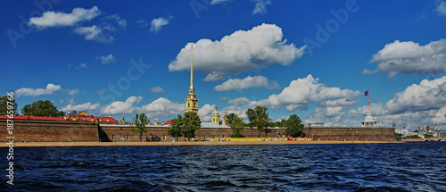Panorama of the Peter and Paul Fortress/View of the Peter and Paul Fortress from the Neva River, Russia, noon, sun in the zenith, water landscape