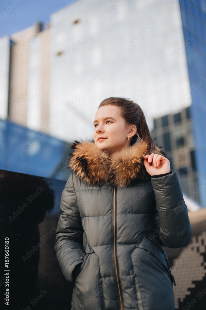 Office place with girl stand near building. Smiling girl look at camera and around with pretty face. Office worker break, winter time. Office place with girl stand near building. Smiling girl look at camera and around with pretty face. Office worker break, winter time.