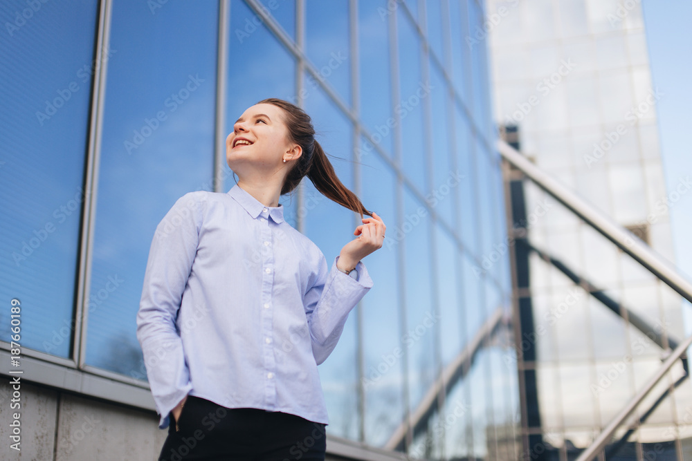 Office place with girl stand near building. Smiling girl look at camera and around with pretty face. Office worker break, winter time. Office place with girl stand near building. Smiling girl look at camera and around with pretty face. Office worker break, winter time.