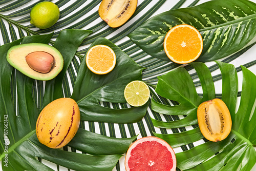 Creative Tropical Layout. Palm Leaves and Fresh Fruits. Colorful Summer Design Set. Healthy Art Food concept. Nature Bright Summer background. Flat lay.