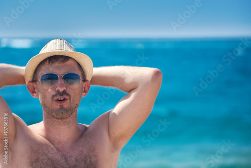 Man in sunhat having  a rest on sea coast. © Artem