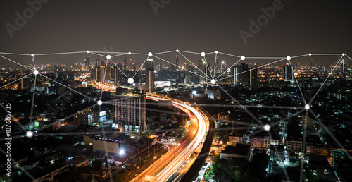 Night time city scape with connecting dots for networking and communication.