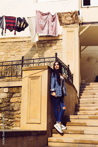 strong beautiful girl posing against a colorful architecture of Baku city in Azerbaijan