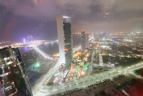 ABU DHABI, UAE - DECEMBER 8, 2016: Aerial view of Corniche Road buildings at night. The city attracts 10 million tourists annually