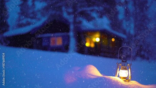 Lantern and mountain cabin in a wintry environment