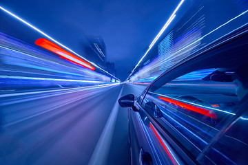 View from Side of Car moving in a night city, Blured road with lights with car on high speed. Concept rapid rhythm of a modern city.