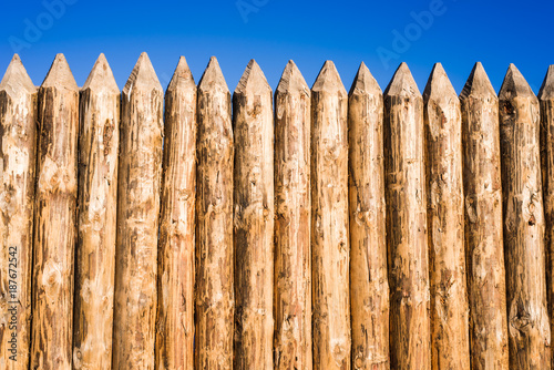 Wooden fence made of sharpened planed logs