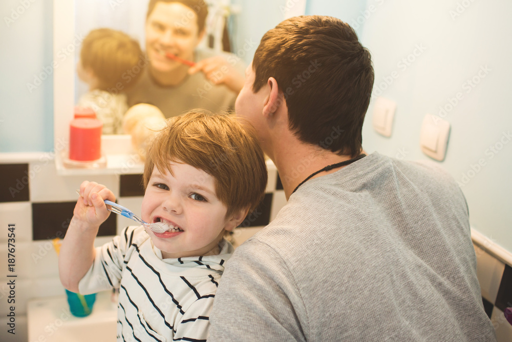 Young father with his son brushing teeth Young father with his son brushing teeth