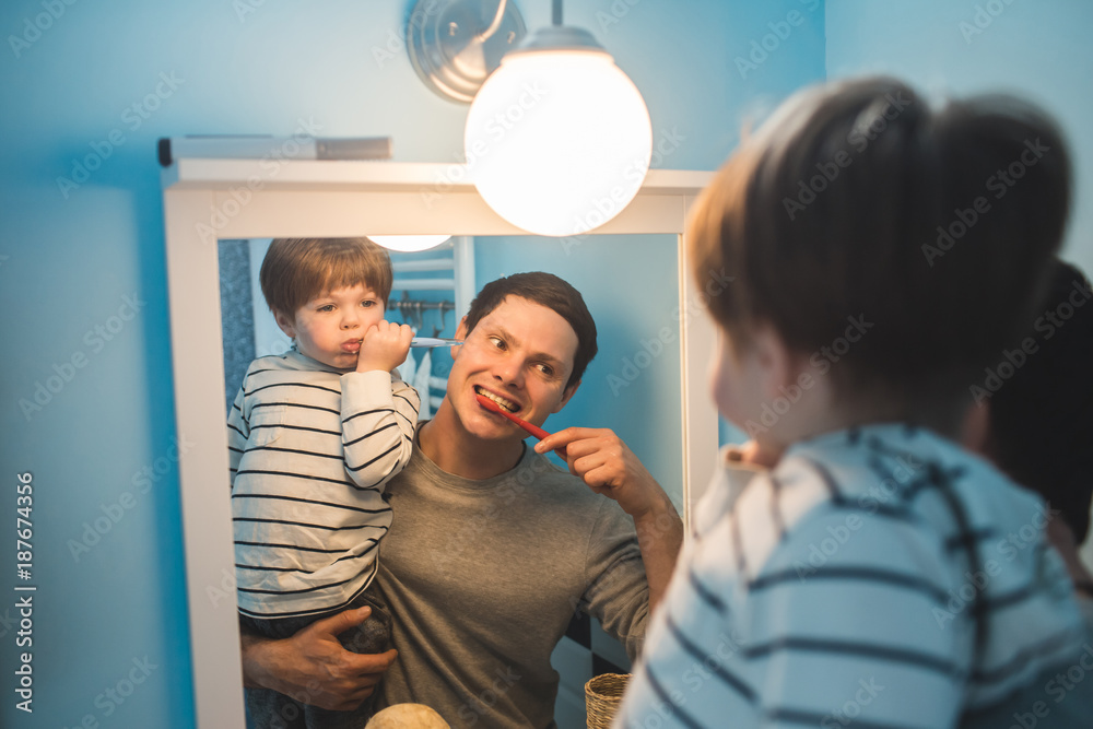 Young father with his son brushing teeth Young father with his son brushing teeth