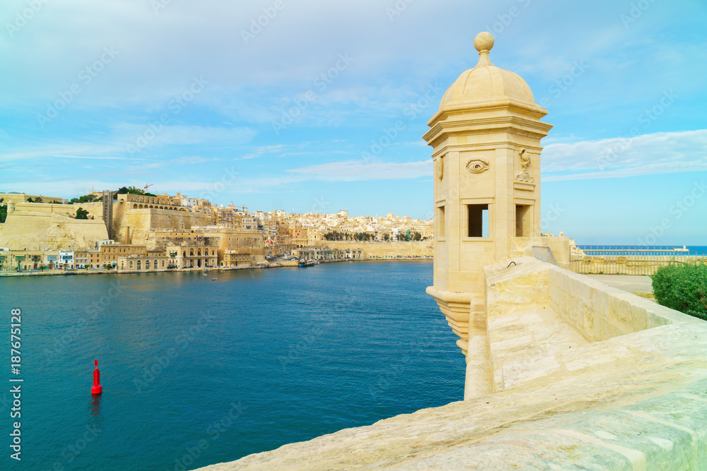The beautiful limestone ancient traditional watch tower view from the Gardjola Gardens in Senglea towards overlooking the Grand Harbour and Valletta, Malta.