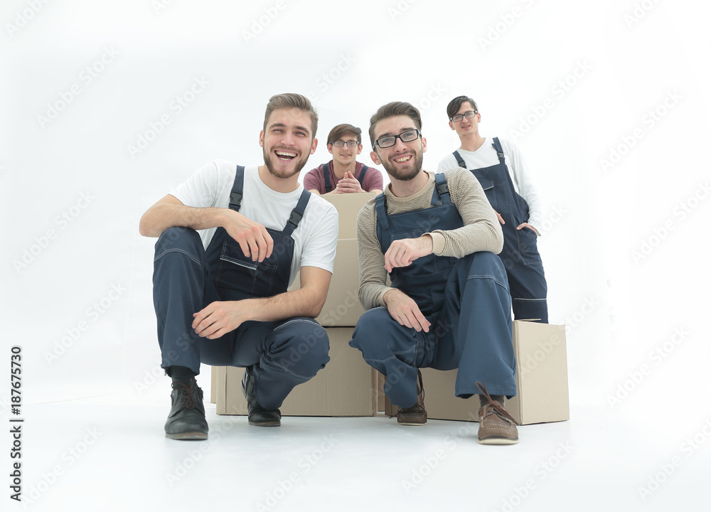 Smiling young delivery men holding stack of boxes. Isolated on w Smiling young delivery men holding stack of boxes. Isolated on w