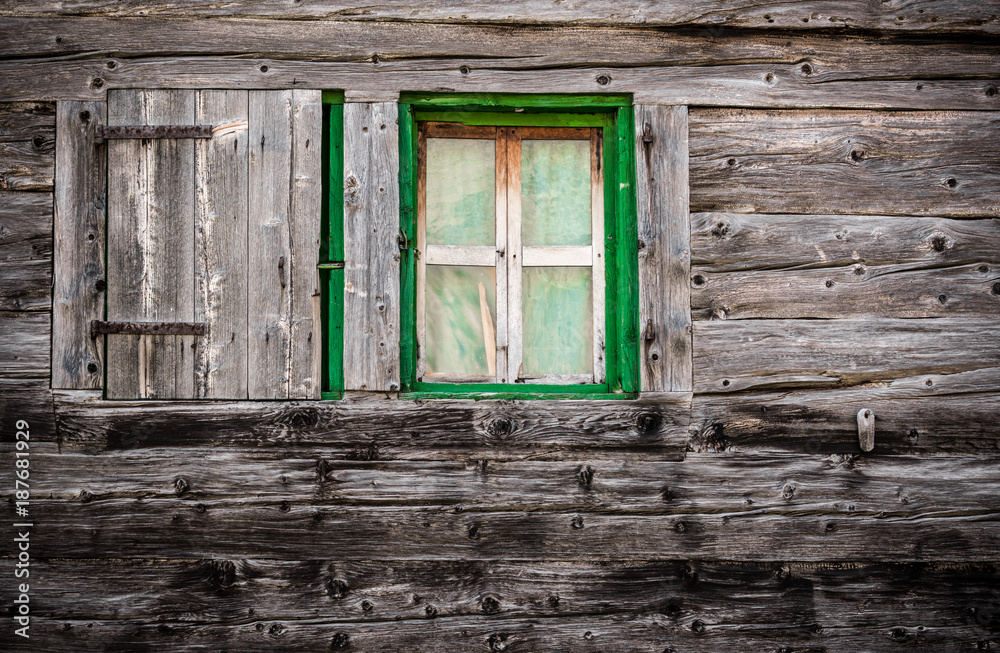 Wooden wall with green window
