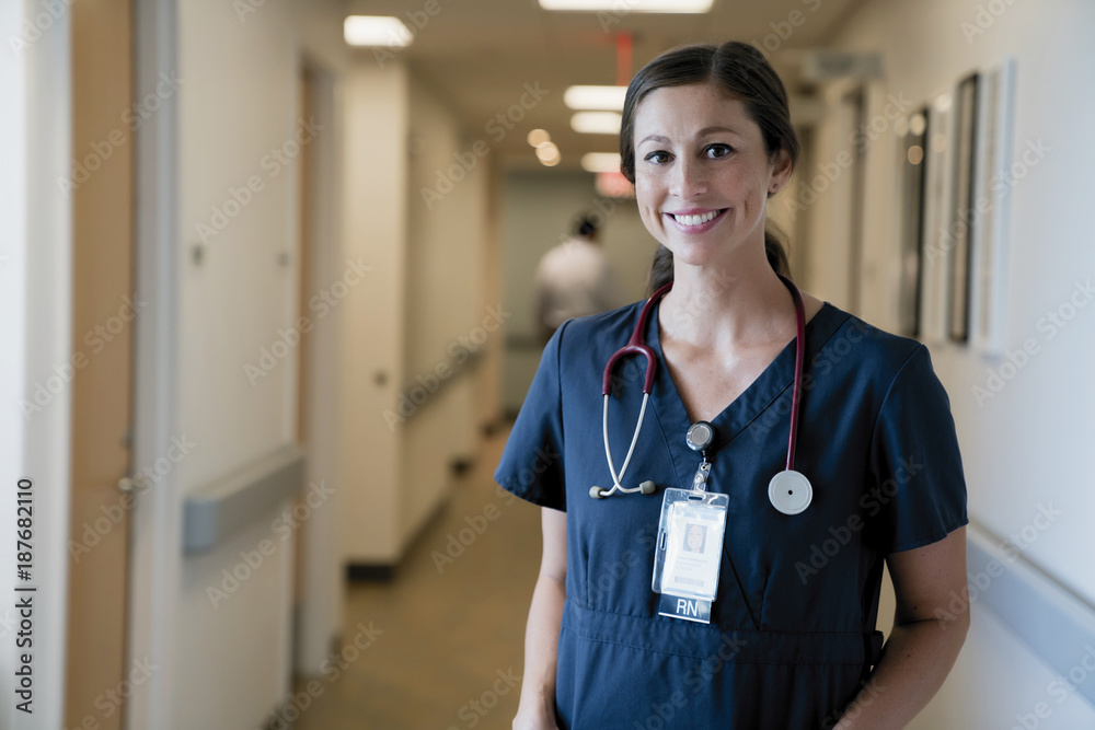 Portrait of cheerful female doctor standing in hospital lobby Portrait of cheerful female doctor standing in hospital lobby