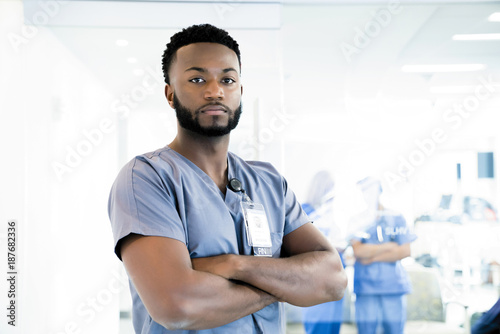 Portrait of confident nurse with arms crossed standing in hospital photo