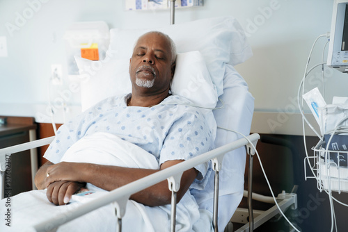 Senior patient sleeping on bed in hospital ward photo